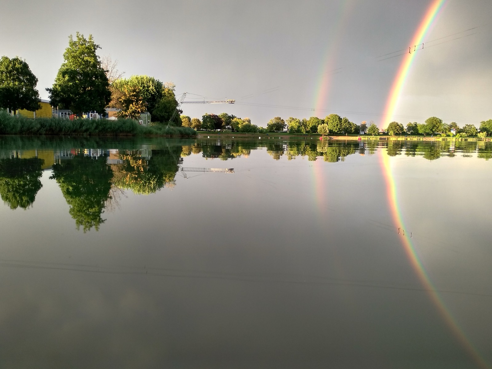 Spiegelglatter See mit Regenbogen